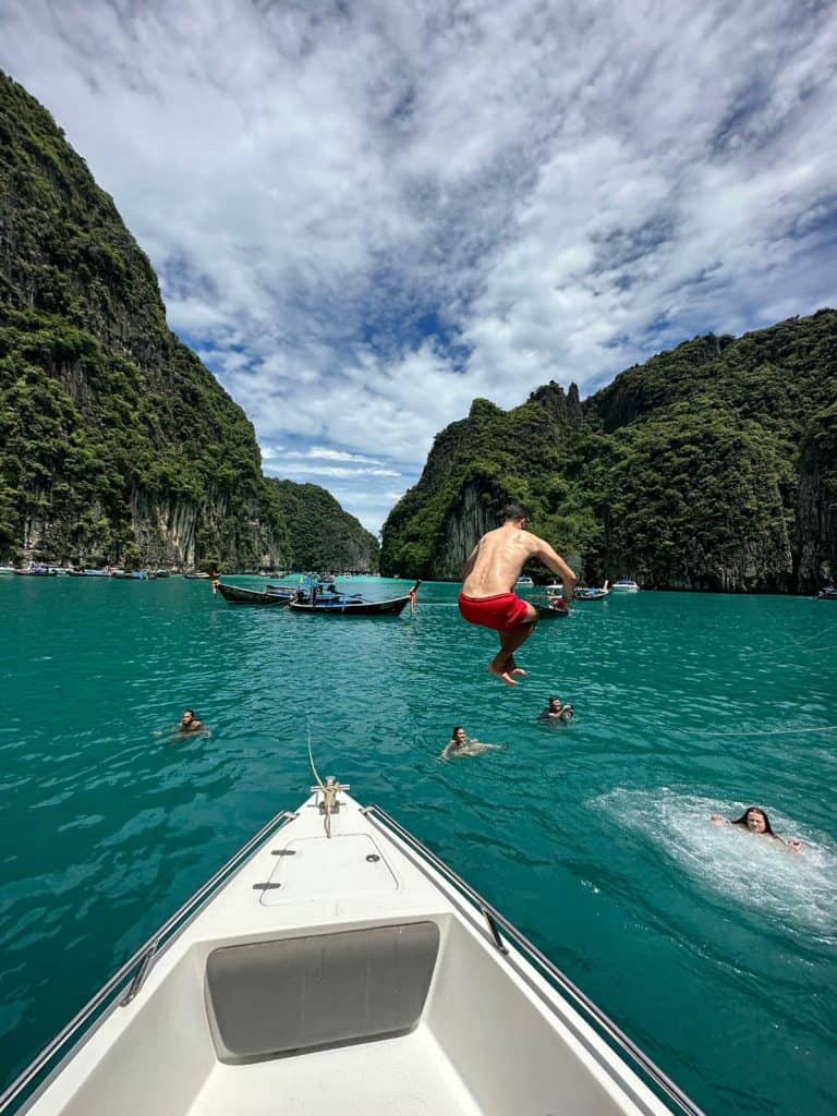 Tourist Jumping from a boat for snorkeling at Pileh Lagoon, Phi Phi Leh Island.